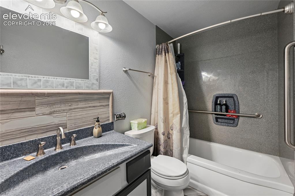 Image 29 of 50: Main Bathroom featuring a built-in tub and shower combination with a curved