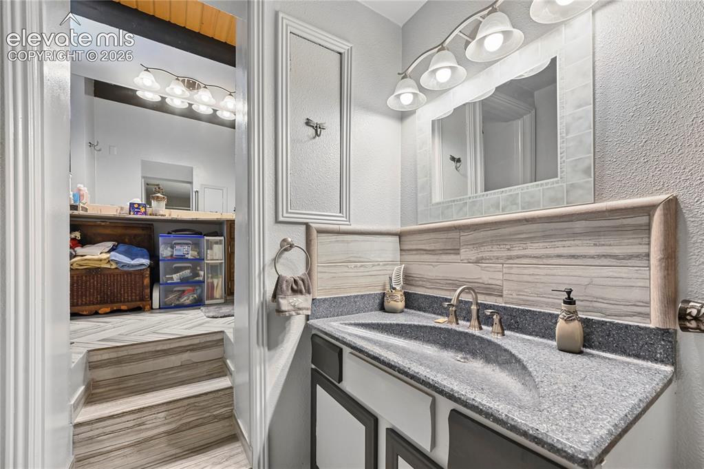 Image 30 of 50: Vanity with integrated sink, brushed nickel faucet, and a tiled backsplash