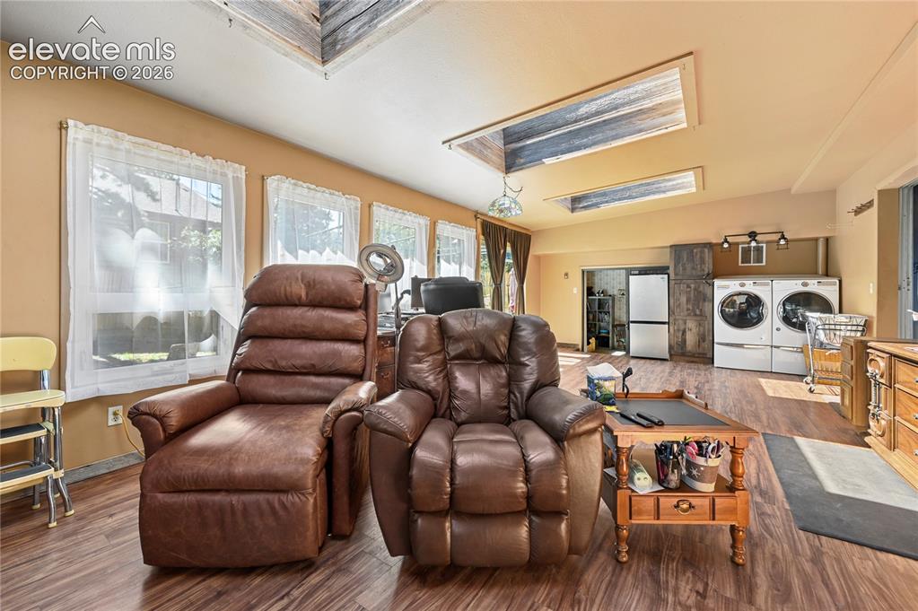 Image 36 of 50: Sloped ceiling with recessed skylights, wood-finish flooring, multiple wind