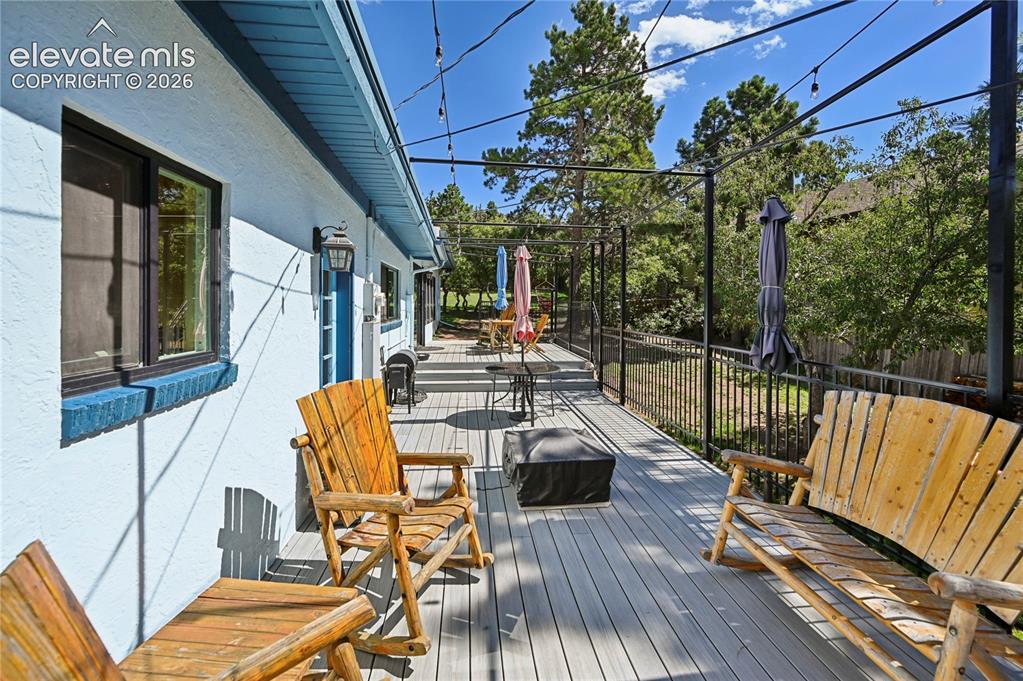 Image 39 of 50: Expansive outdoor deck with gray composite decking, black metal railing, an