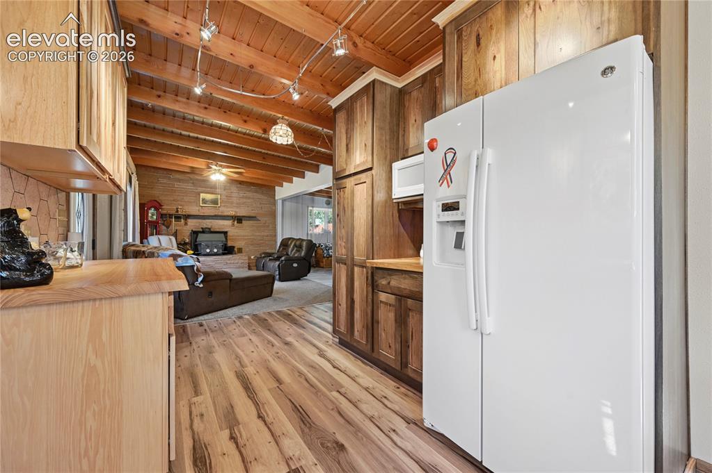 Image 4 of 50: Vaulted wood plank ceiling with exposed beams, wood-finish flooring, wood c