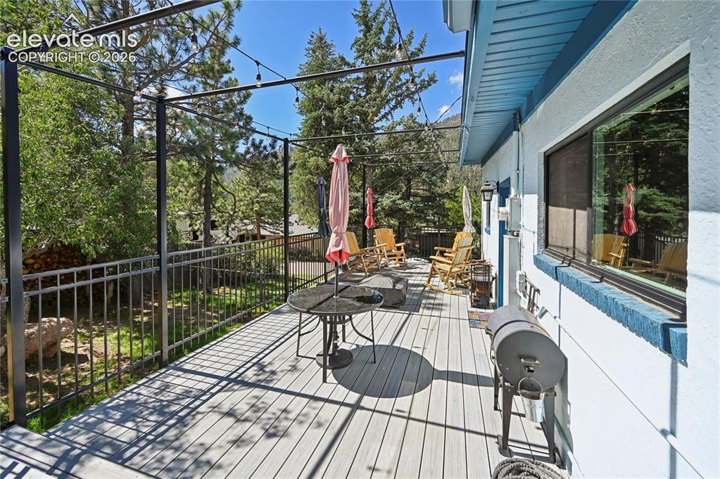 Image 40 of 50: Expansive deck with composite decking, decorative metal railing, string lig