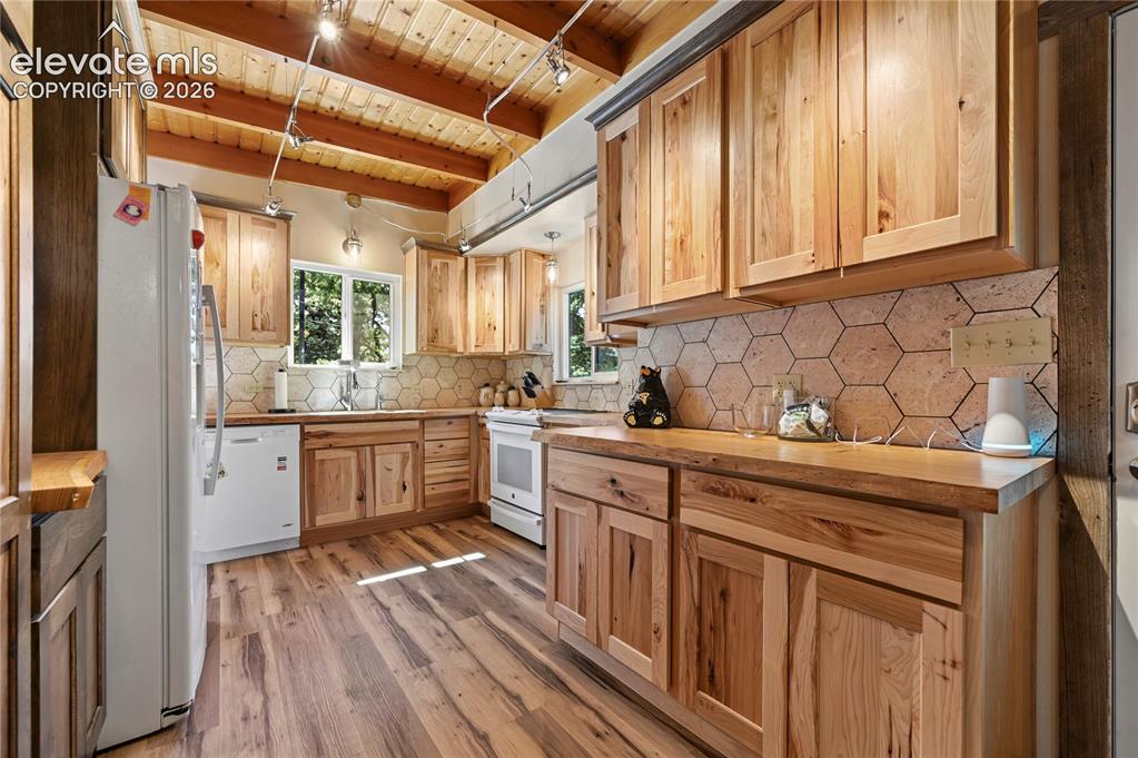 Image 6 of 50: Kitchen featuring wood-finish flooring, natural wood cabinetry, wood counte