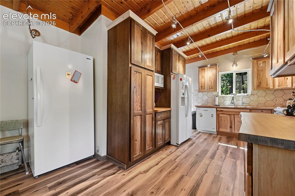 Image 7 of 50: Wood-finish flooring throughout, complemented by wood cabinetry and a wood-