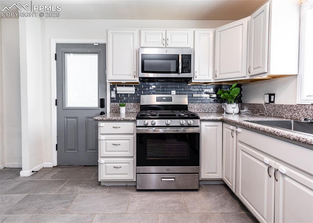 Image 11 of 25: Kitchen with appliances with stainless steel finishes, healthy amount of na