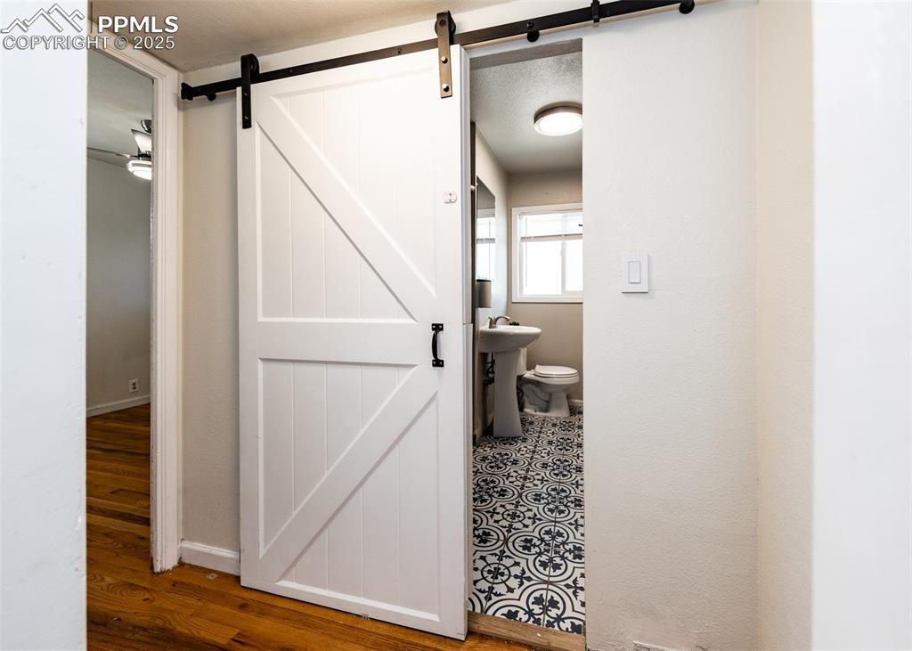 Image 14 of 25: Half bathroom with wood finished floors, baseboards, and toilet