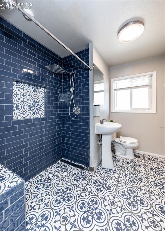 Image 17 of 25: Full bath featuring tiled shower and toilet