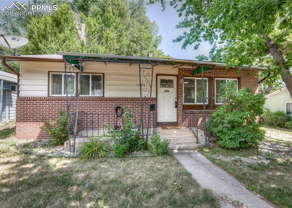 Image 2 of 25: View of front of property with brick siding and a porch