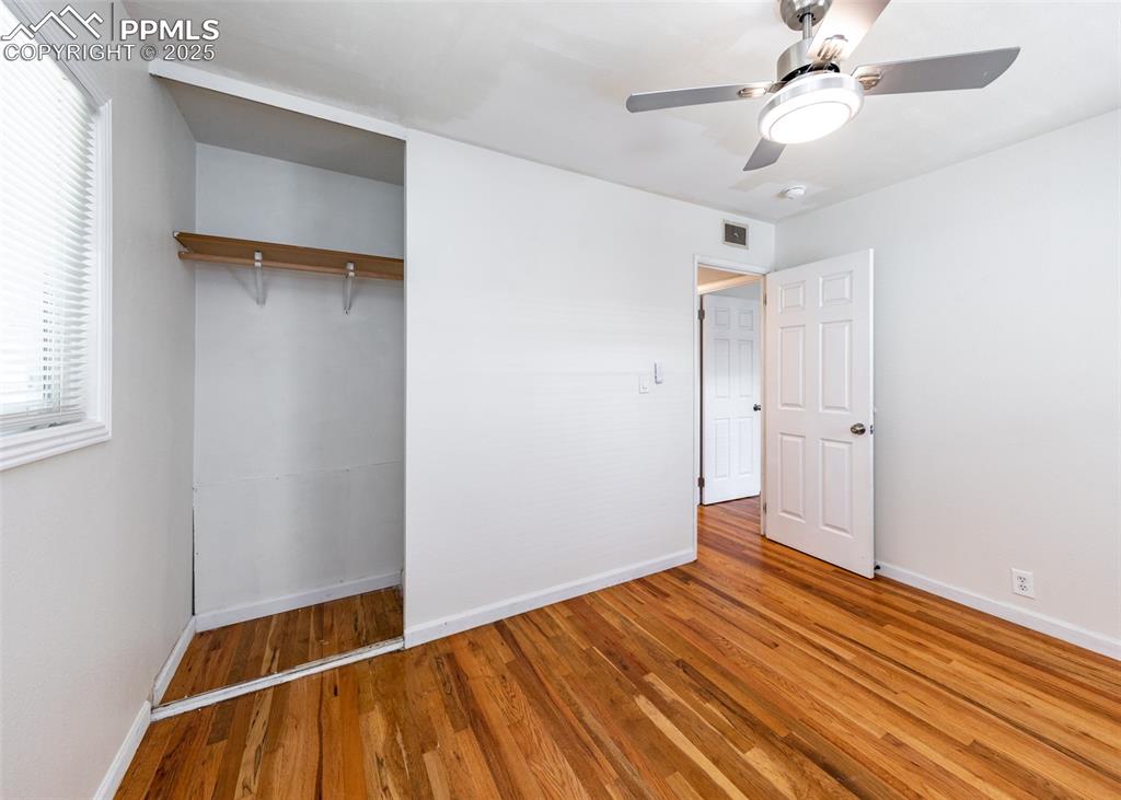 Image 21 of 25: Unfurnished bedroom with baseboards, wood finished floors, multiple windows