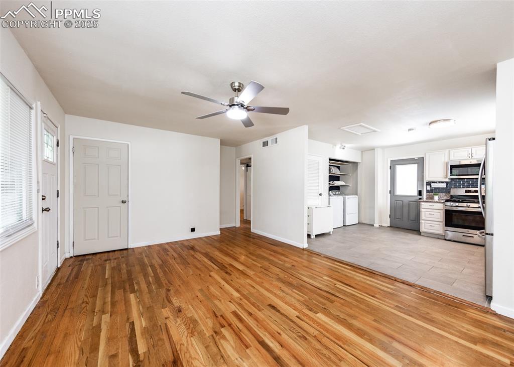 Image 7 of 25: Unfurnished living room featuring washing machine and clothes dryer, light 