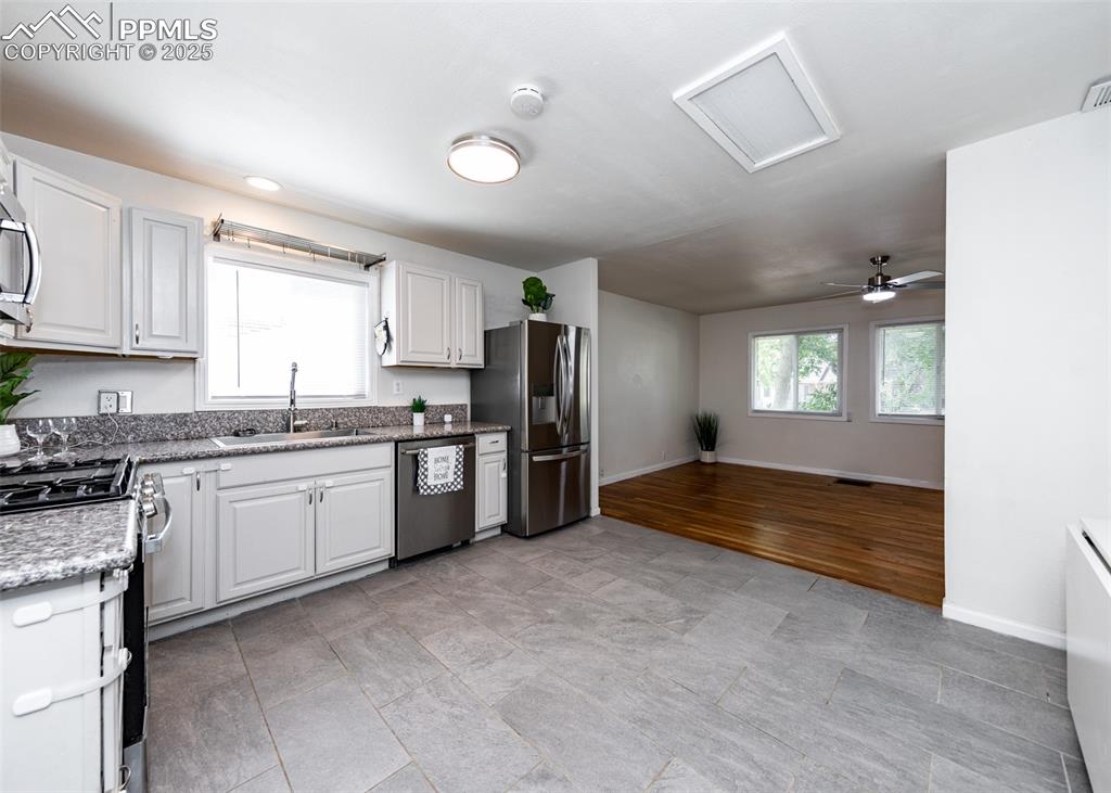 Image 9 of 25: Kitchen with appliances with stainless steel finishes, a sink, baseboards, 