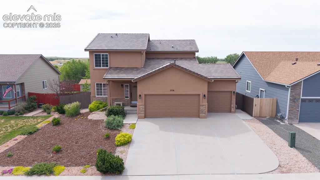 Image 1 of 50: Stucco exterior with stone accents, a three-car garage, and a concrete driv