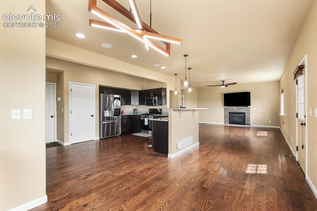 Image 11 of 50: Spacious open-concept living area featuring rich wood-finish flooring, a co