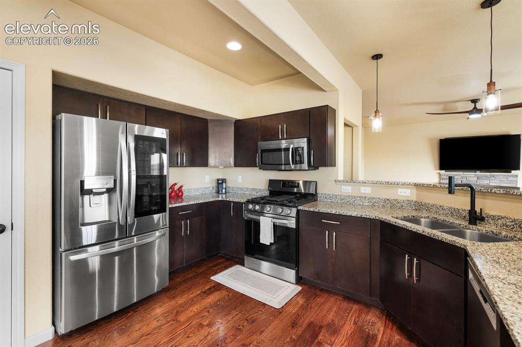 Image 13 of 50: Kitchen featuring wood-finish flooring and dark wood cabinetry