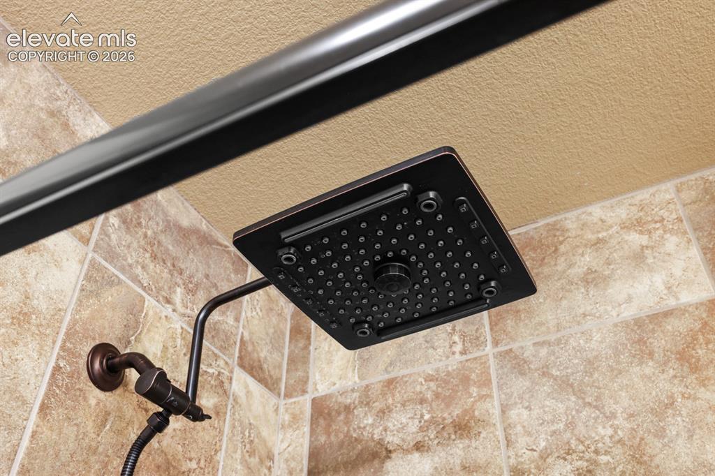 Image 24 of 50: Oil-rubbed bronze rainfall shower head with a square design