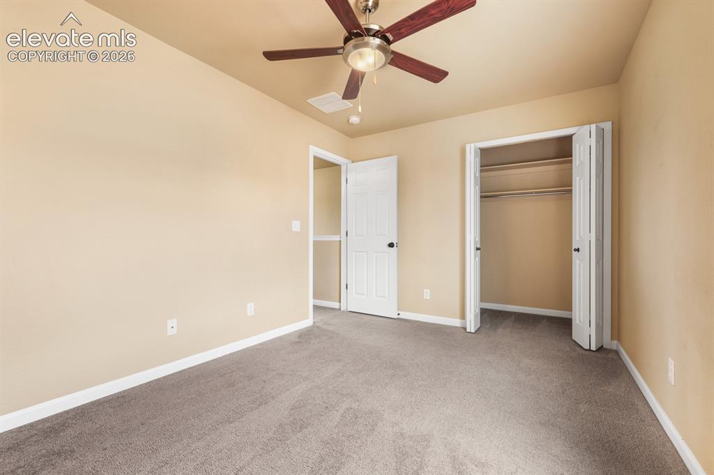 Image 32 of 50: Carpeted interior room featuring a ceiling fan with integrated lighting, a