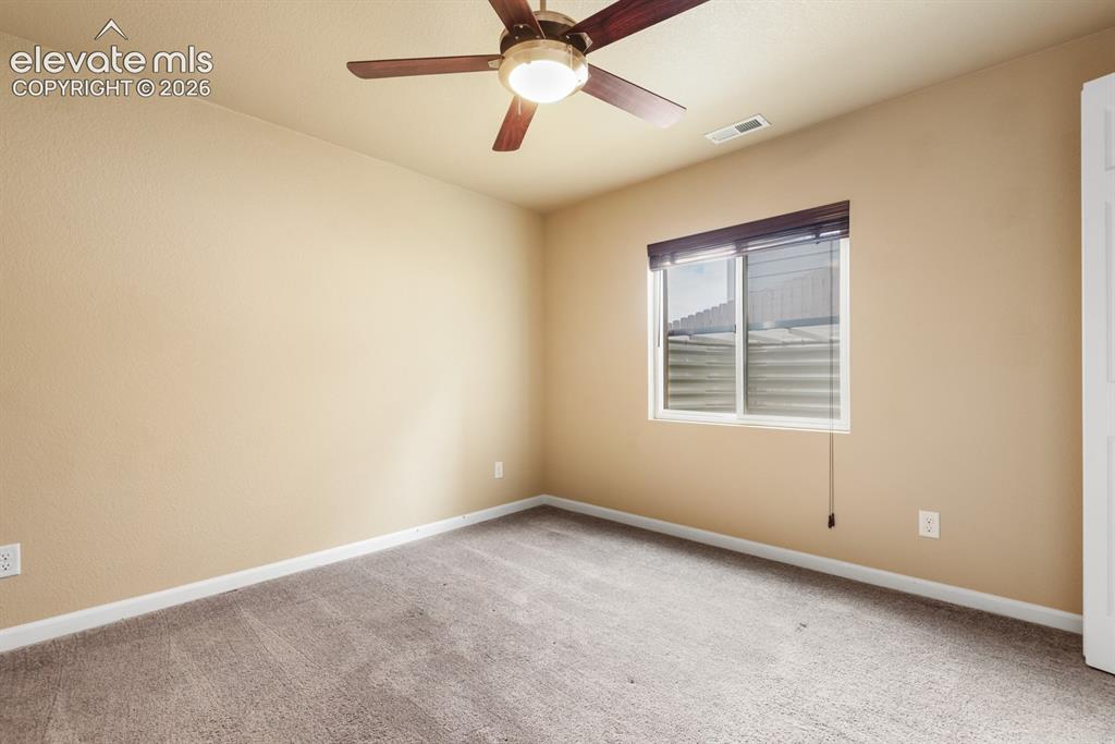 Image 40 of 50: Neutral-toned room featuring a ceiling fan with integrated lighting, a wind