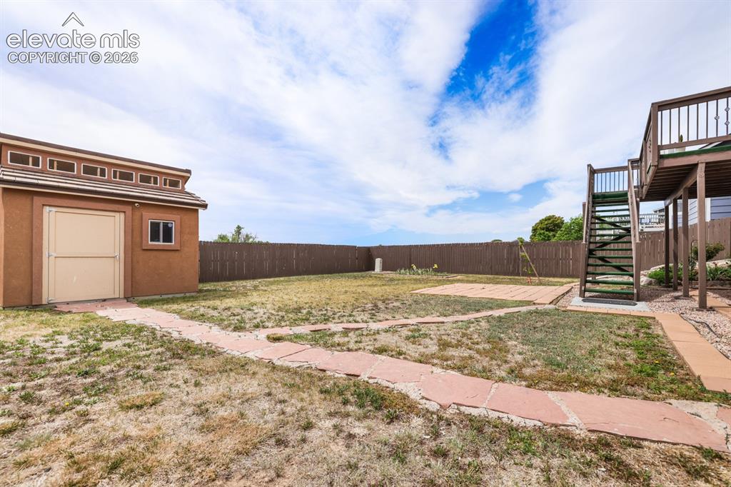 Image 46 of 50: Expansive backyard featuring a detached storage shed with clerestory window
