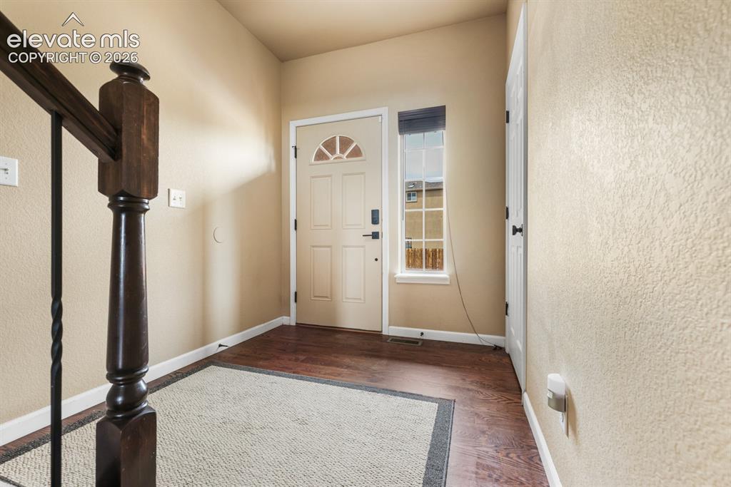 Image 5 of 50: Entryway featuring wood-finish flooring, a six-panel entry door with an arc