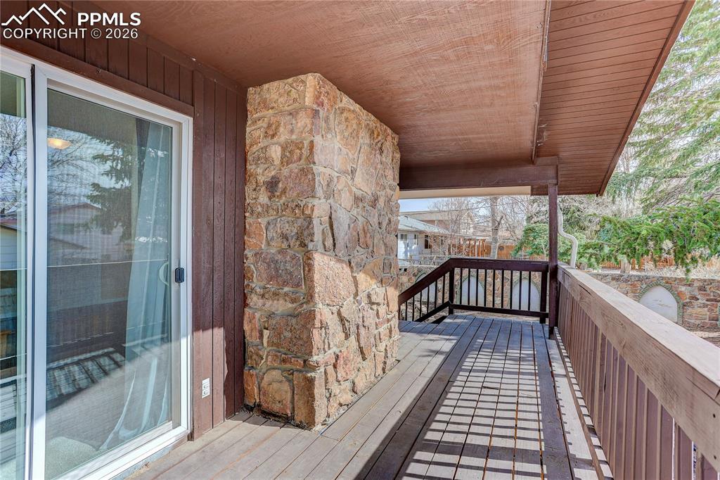 Image 27 of 37: Covered deck off the primary bedroom overlooking the backyard.