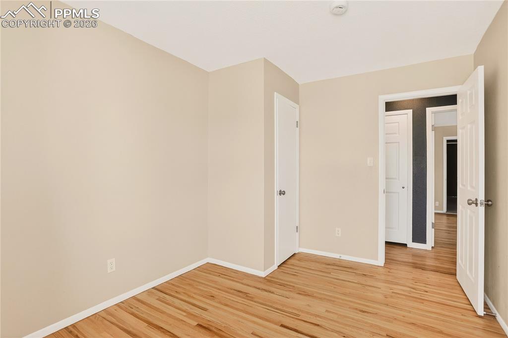 Image 31 of 37: Bedroom with hardwood flooring.