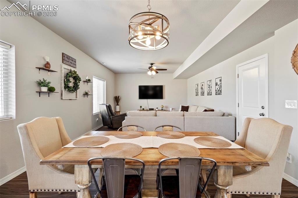 Image 10 of 46: Open-concept living area featuring a rustic wood-finish dining table, a con