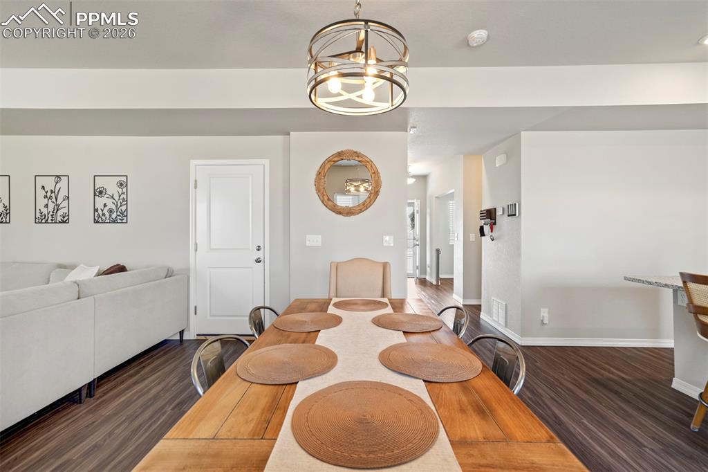 Image 11 of 46: Open-concept living space featuring wood-finish flooring, a contemporary ch