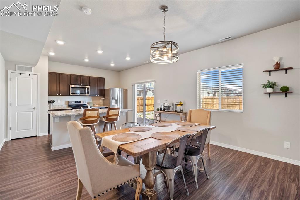 Image 12 of 46: Open-concept living area featuring wood-finish flooring, a contemporary din