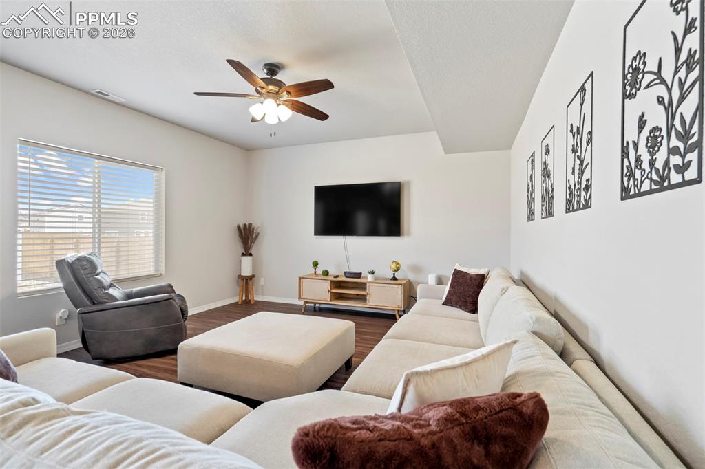 Image 13 of 46: Spacious living area featuring wood-finish flooring, a contemporary ceiling
