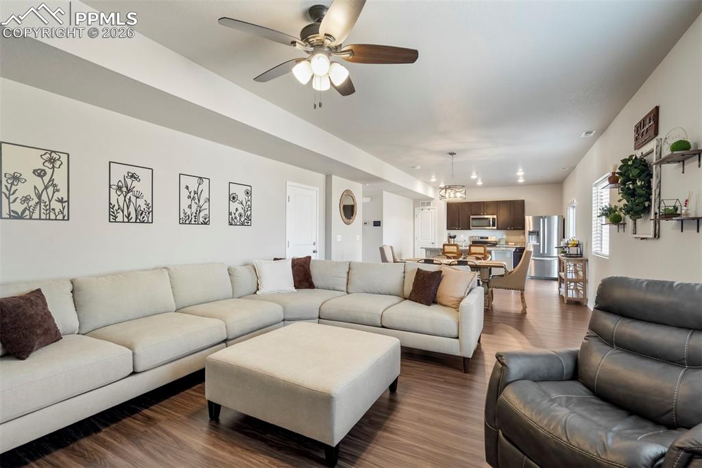 Image 15 of 46: Open-concept living area featuring wood-finish flooring, a contemporary cei