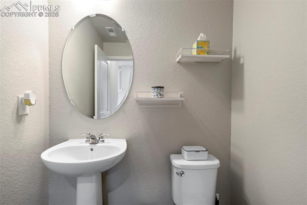 Image 18 of 46: Bathroom featuring a pedestal sink with chrome faucet, an oval frameless mi