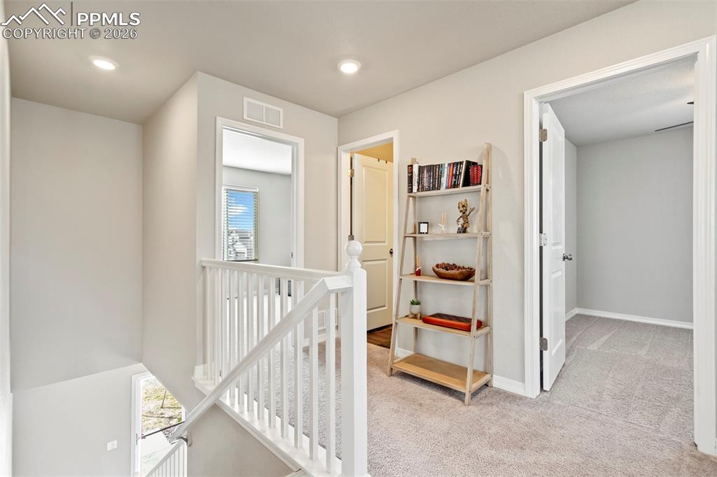 Image 20 of 46: Upper-level landing featuring light gray wall paint, recessed lighting, whi