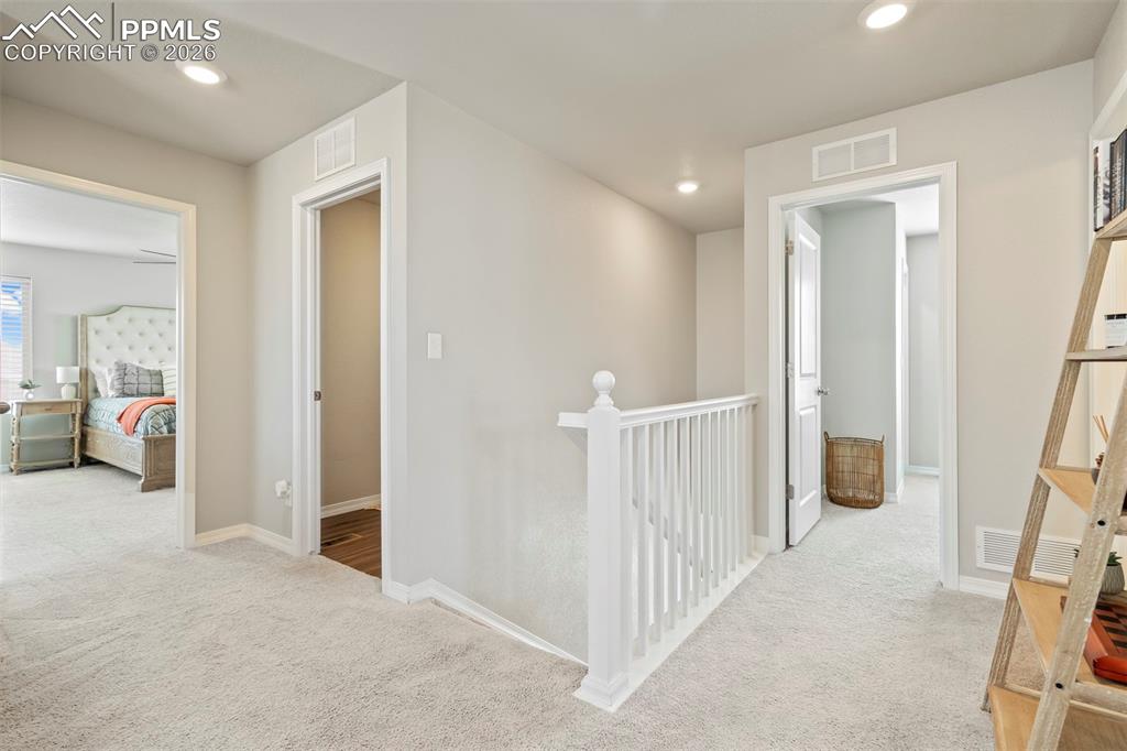 Image 21 of 46: Upper-level landing featuring light-toned carpeting, recessed lighting, and