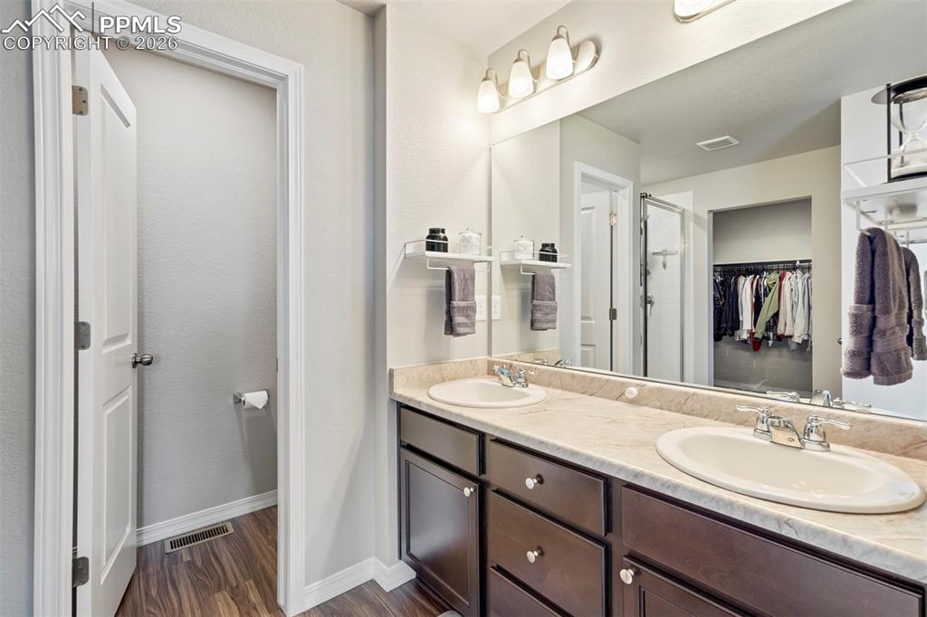 Image 27 of 46: Double vanity featuring oval undermount sinks, chrome fixtures, and a light