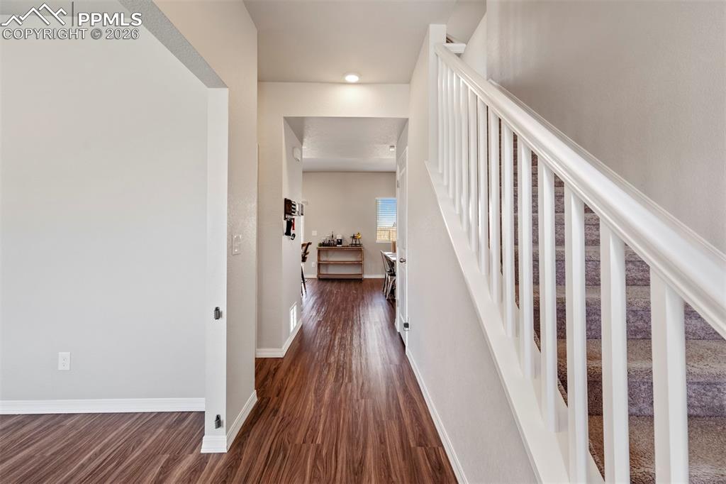 Image 3 of 46: Spacious entryway featuring wood-finish flooring, a white baluster staircas