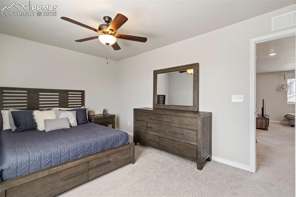 Image 32 of 46: Carpeted bedroom featuring a ceiling fan with light fixture, light gray wal