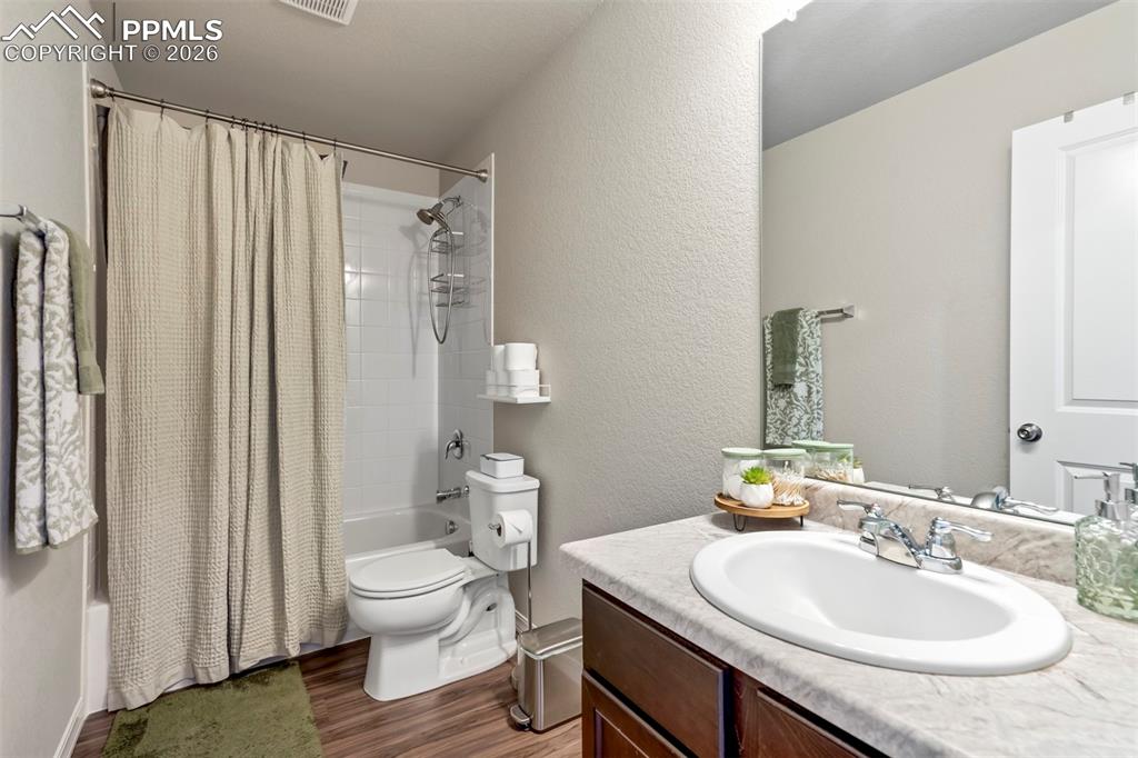 Image 33 of 46: Full bathroom featuring a single vanity with an integrated sink, a dark woo