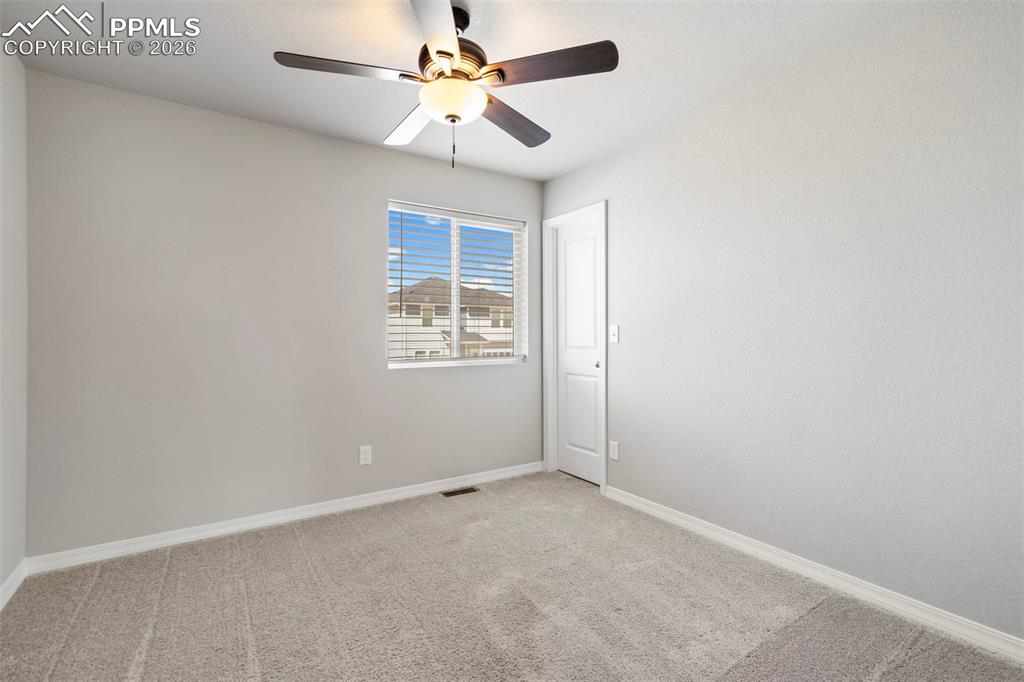 Image 35 of 46: Neutral-toned room featuring a ceiling fan with integrated lighting, a wind