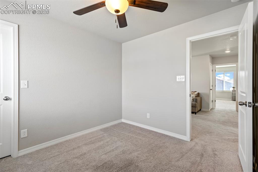 Image 36 of 46: Carpeted interior room with light grey walls and white trim