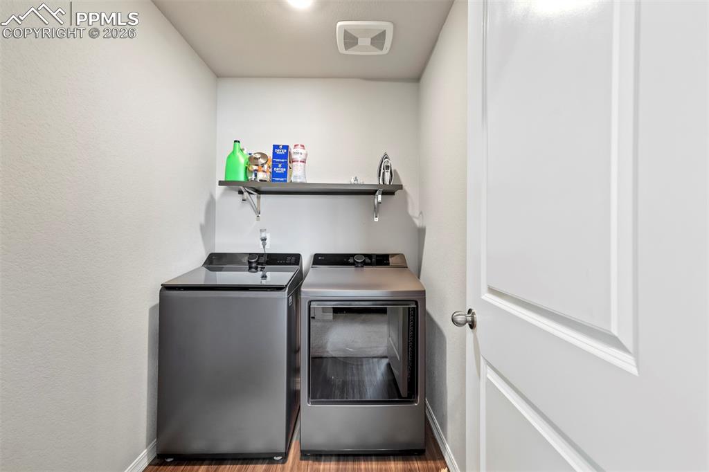 Image 38 of 46: Dedicated utility area featuring wood-finish flooring, light neutral walls,