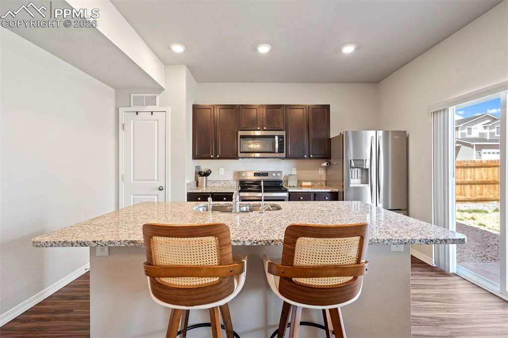 Image 6 of 46: Kitchen island with granite countertop and integrated sink