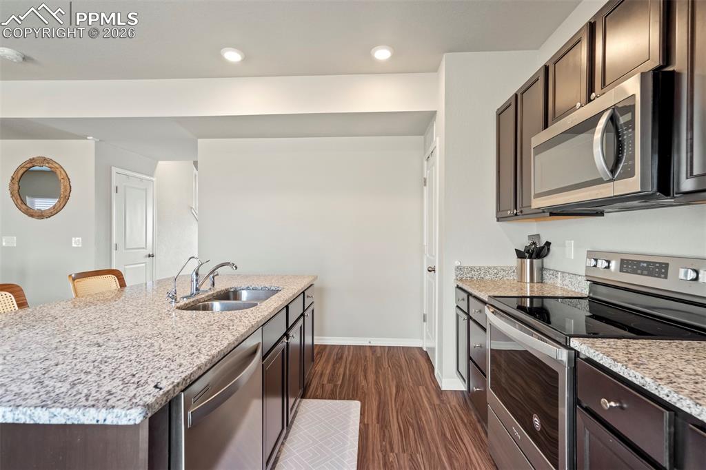 Image 8 of 46: Kitchen featuring an island with a double basin sink, stainless steel dishw