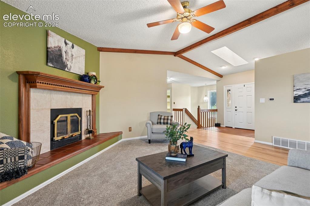 Image 15 of 50: Living area with new carpet, natural hardwood flooring