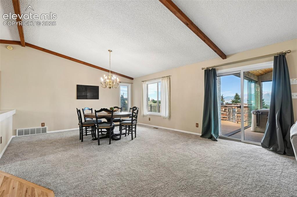 Image 16 of 50: Vaulted ceiling with wood beam accents