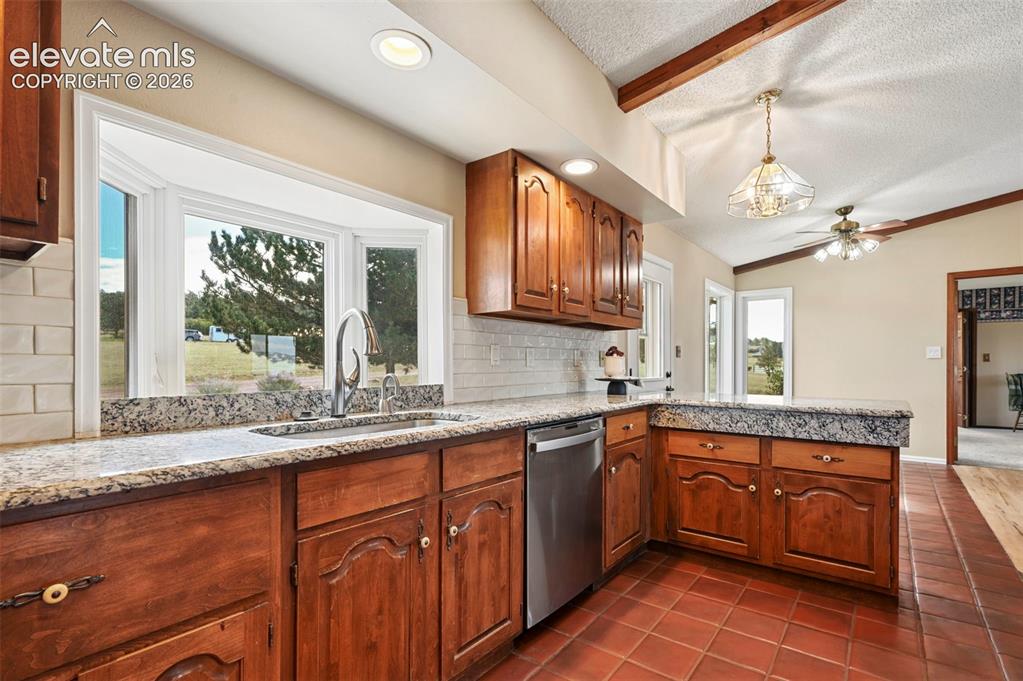 Image 18 of 50: Tile backsplash, stainless appliances, hot water tap, granite countertops
