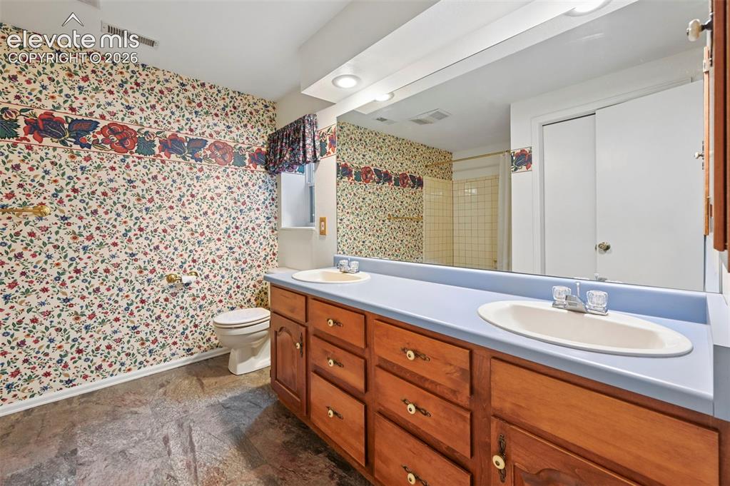 Image 31 of 50: Full bath downstairs with tub/shower and double vanities.