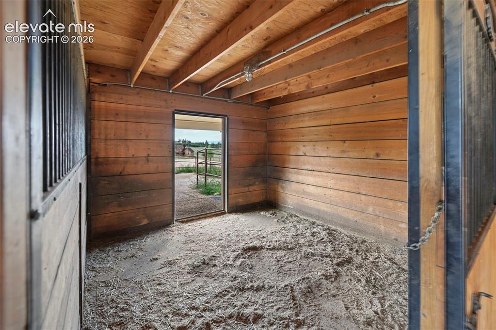 Image 44 of 50: Interior stall with wood plank walls and corall access