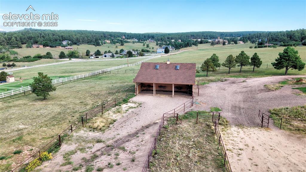 Image 47 of 50: Expansive equestrian facility featuring barn with multiple stalls, fenced p