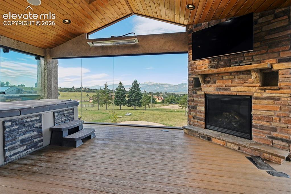 Image 7 of 50: Bringing the outdoors in with Glassed In Sun room w hot tub and gas firepla