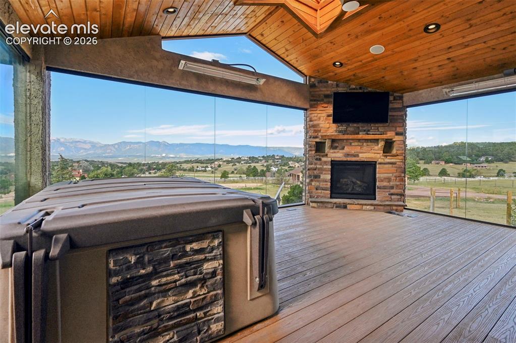 Image 8 of 50: Enclosed patio featuring a stone fireplace, natural wood ceiling and recess